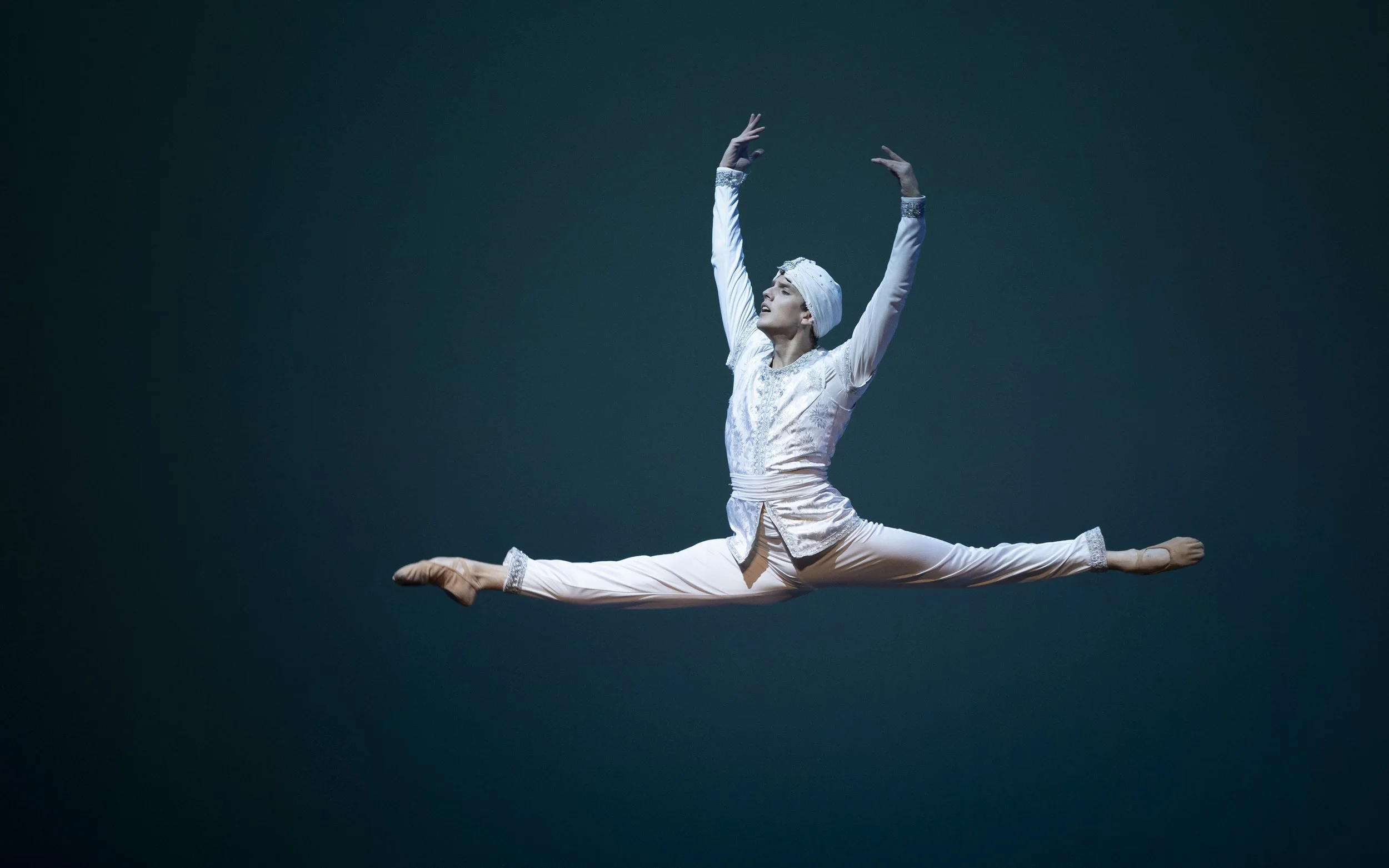 Summer Intensive artistic director Sebastian Vinet performing a grand jeté on stage